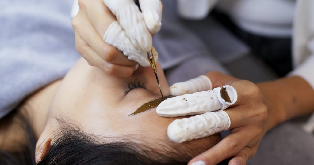 Asian woman gets facial beauty procedure, microblading procedure