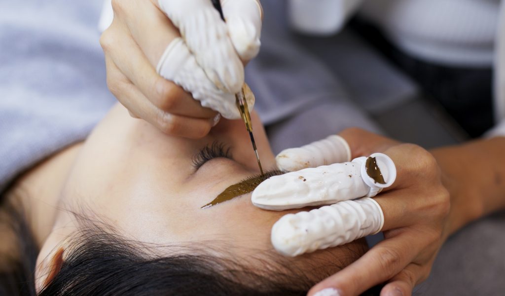 Asian woman gets facial beauty procedure, microblading procedure